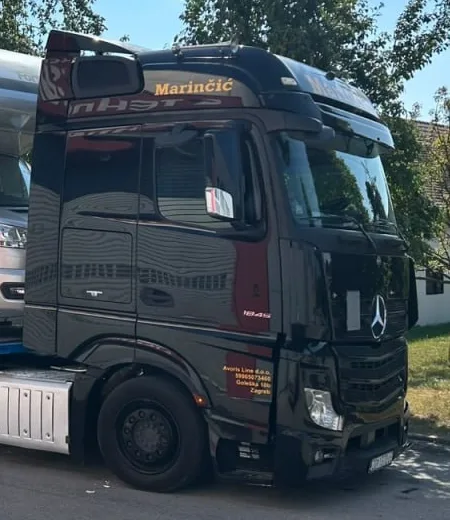 Kabina Actrosa: natpis Marinčić na vizoru i podaci tvrtke Avoris Line d.o.o. na vratima